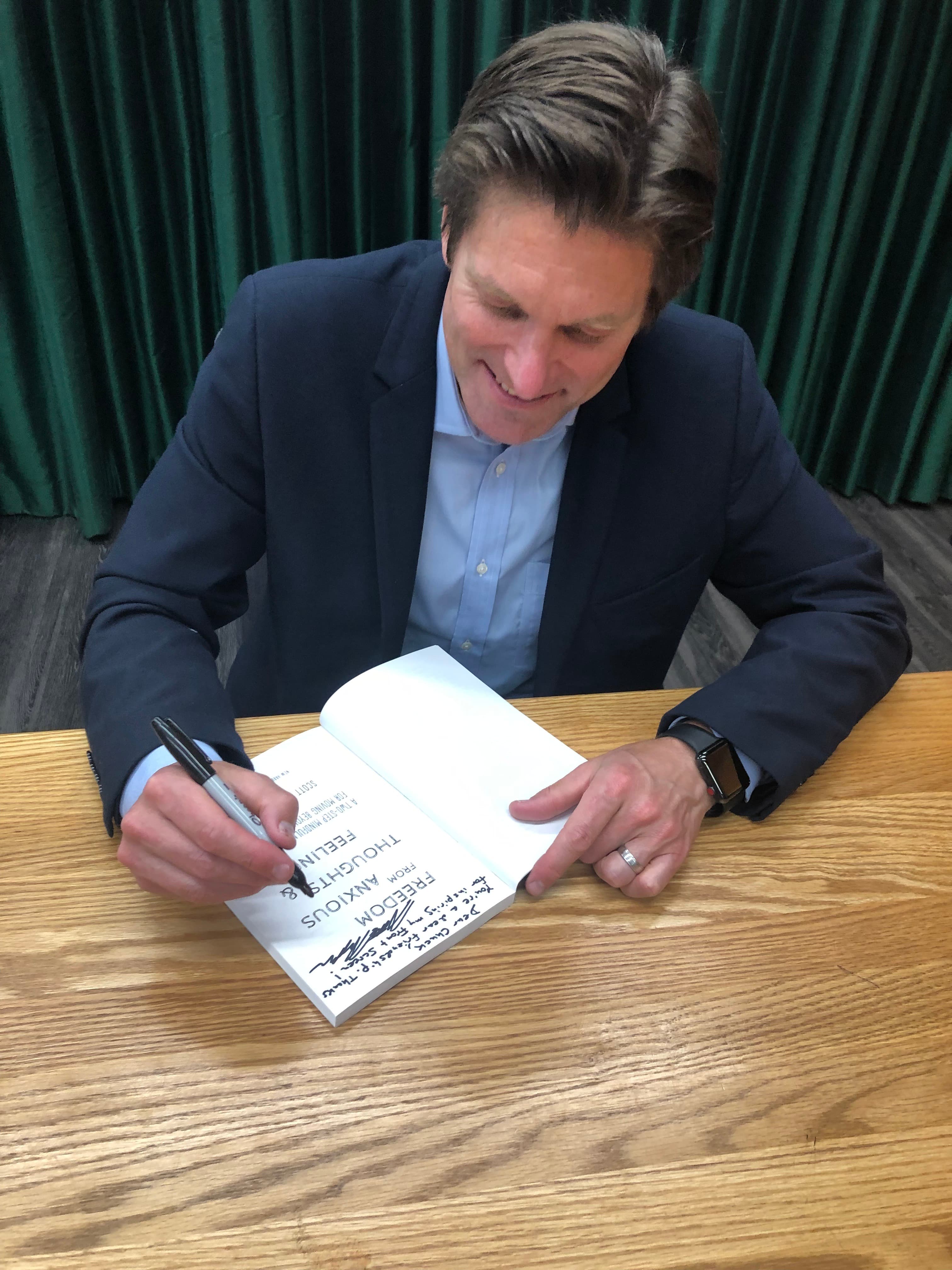 Dr. Scott Symington signing a copy of his book